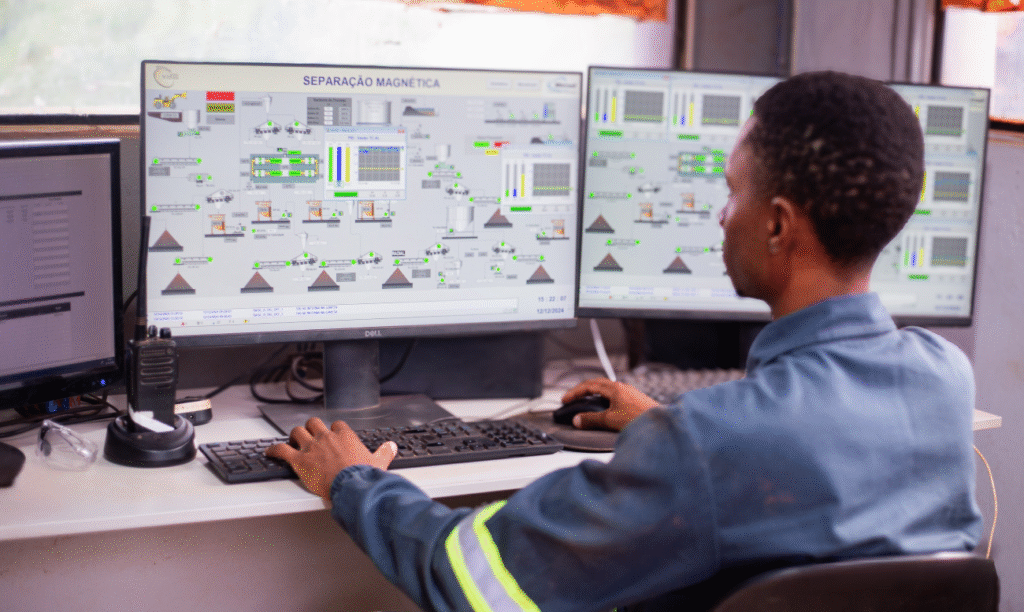 Operador de mineração usando software de controle de produção e separação magnética em múltiplas telas na central de monitoramento.