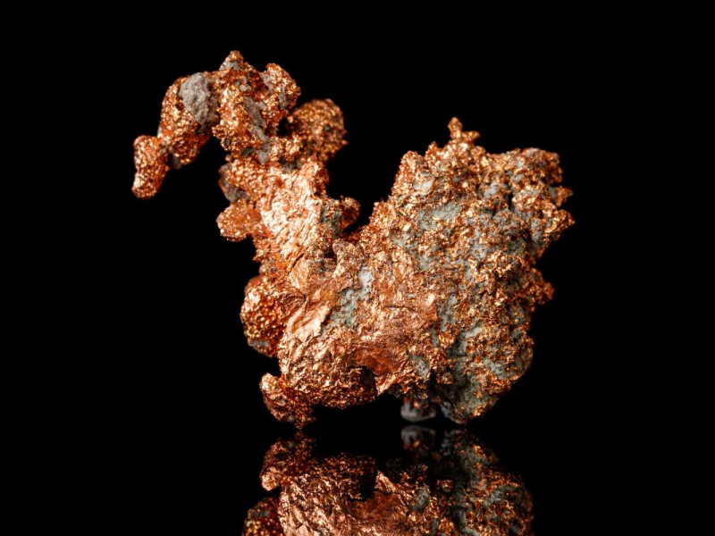 Pepita de cobre bruto sobre fundo preto, representando minerais críticos no Brasil.